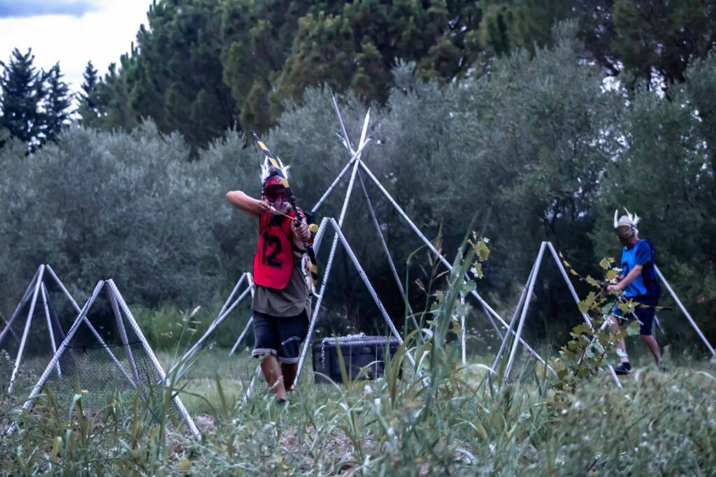 Guillaume de Arksiders, un jeu d'aventure immersif, se tient au milieu du terrain prêt à tirer avec son arc